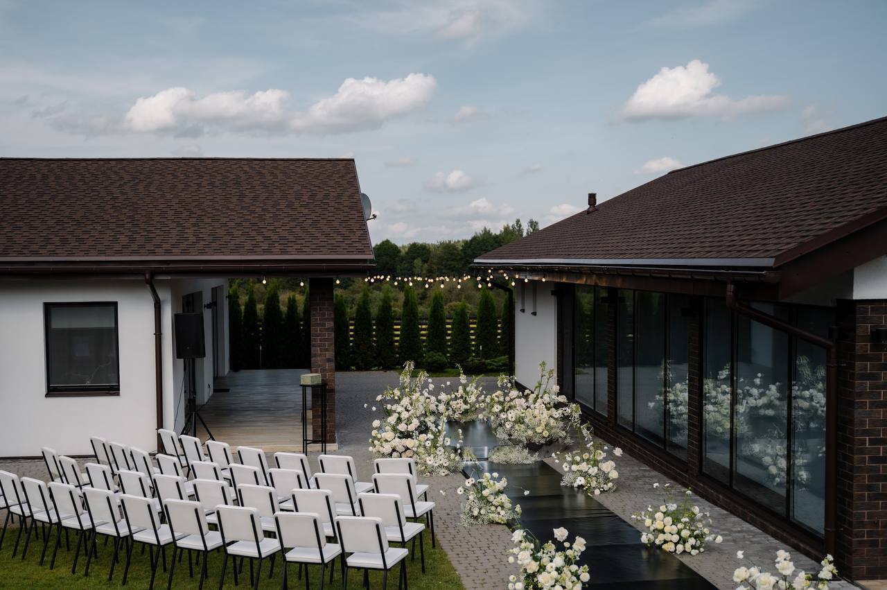 Усадьба Grand Chalet — площадка для церемонии с белыми стульями и цветочными композициями
